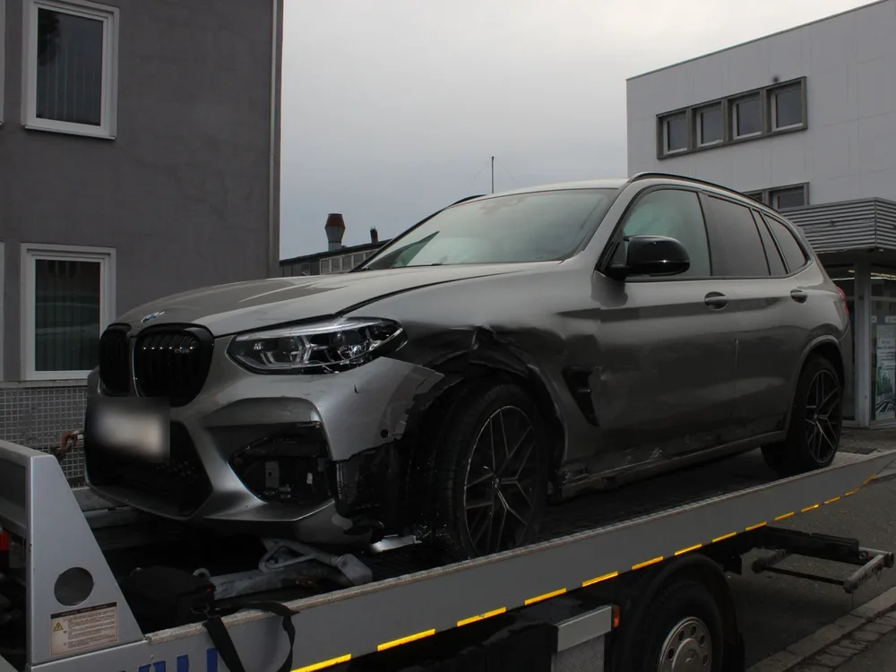 Grauer BMW X3 M auf dem Abschleppwagen, Stoßfänger vorne links abgerissen