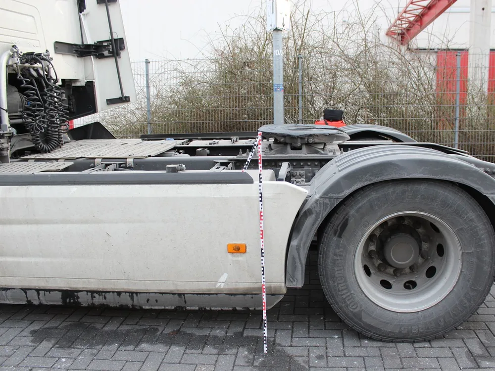 Lkw-Zugmaschine mit Messlatte an der beschädigten Seitenverkleidung